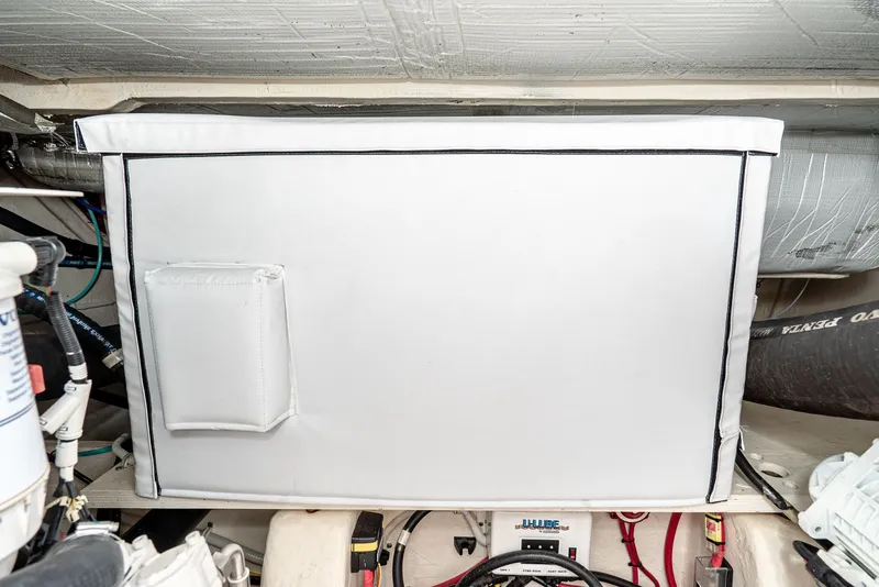 Slide: The Image of A white rectangular box in an engine room with pipes and cables. - 44