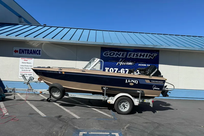 The Image of 1998 Lund 1700 Pro Sport boat on trailer outside Gone Fishin' Marine store. - 1