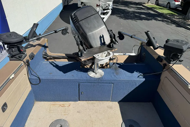 Slide: The Image of 1998 Lund 1700 Pro Sport boat interior with motor and fishing rod holders. - 12