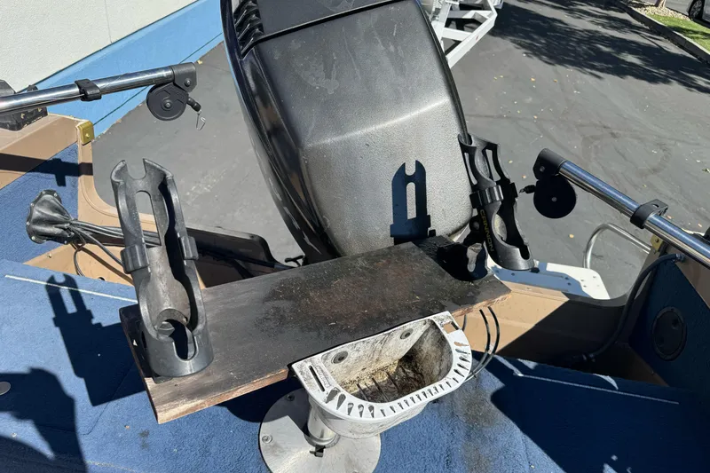 Slide: The Image of 1998 Lund 1700 Pro Sport boat interior with motor and rod holders. - 14