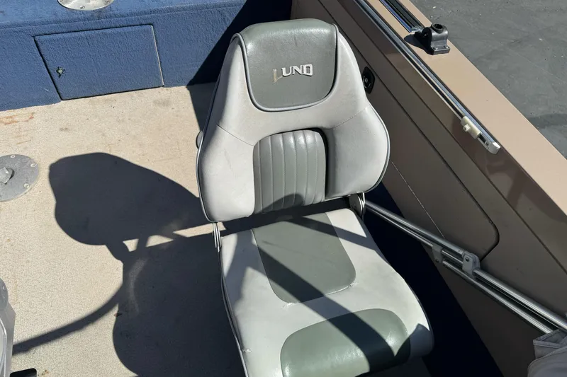Slide: The Image of Lund 1700 Pro Sport 1998 boat seat with gray upholstery and logo. - 16