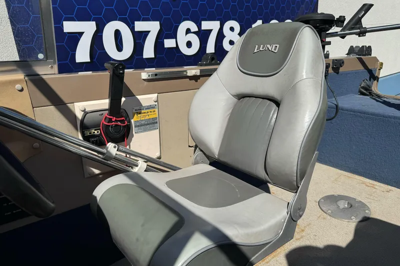 Slide: The Image of 1998 Lund 1700 Pro Sport boat seat and control panel with visible contact number. - 17