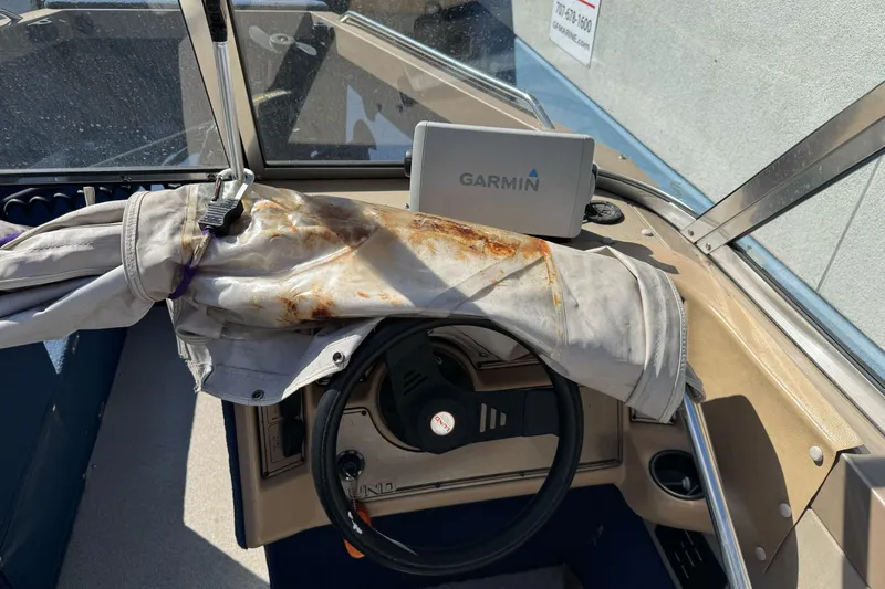 Slide: The Image of 1998 Lund 1700 Pro Sport boat interior with Garmin GPS and weathered steering wheel cover. - 18