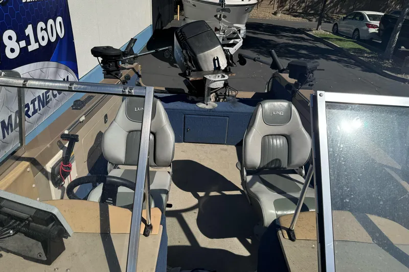 Slide: The Image of 1998 Lund 1700 Pro Sport boat interior with seating and steering console. - 22