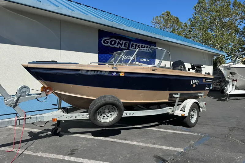 Slide: The Image of 1998 Lund 1700 Pro Sport boat on trailer, parked outside a fishing store. - 3