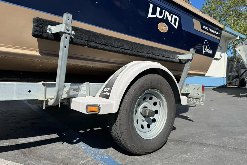 Slide: The Image of 1998 Lund 1700 Pro Sport boat on EZ Loader trailer, parked outdoors. - 4