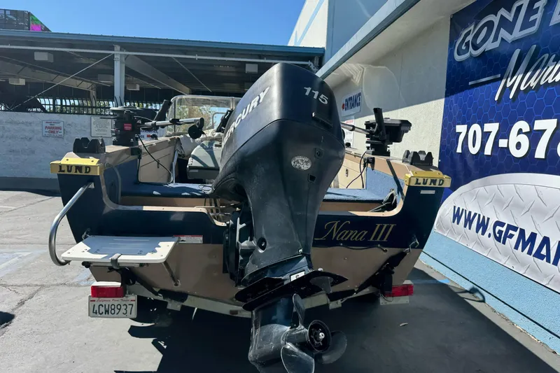 Slide: The Image of 1998 Lund 1700 Pro Sport boat with Mercury engine, parked outside a marine shop. - 6