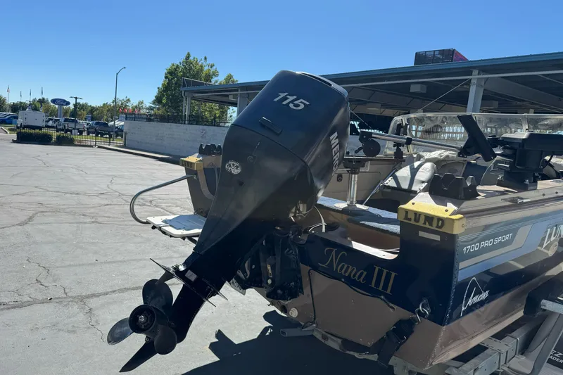 Slide: The Image of 1998 Lund 1700 Pro Sport boat with Mercury 115 outboard motor in parking lot. - 8