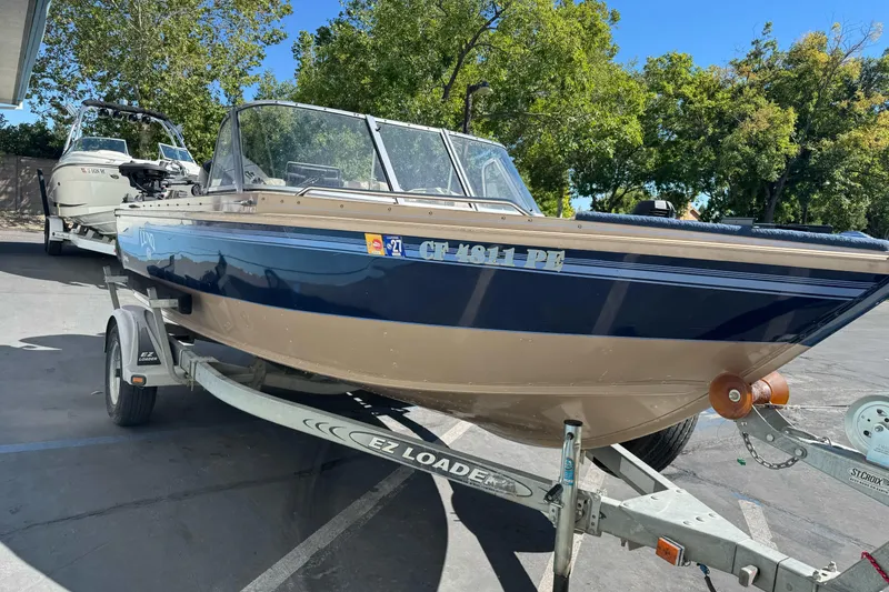Slide: The Image of 1998 Lund 1700 Pro Sport boat on EZ Loader trailer, parked outdoors. - 9