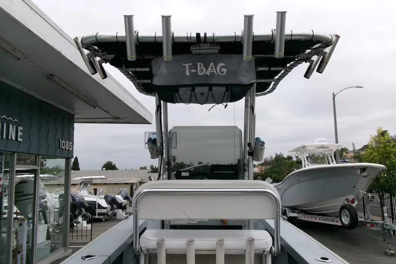 Slide: The Image of 2017 Klamath Bayrunner 19 Baja boat with T-top and rod holders, parked at a marina. - 11