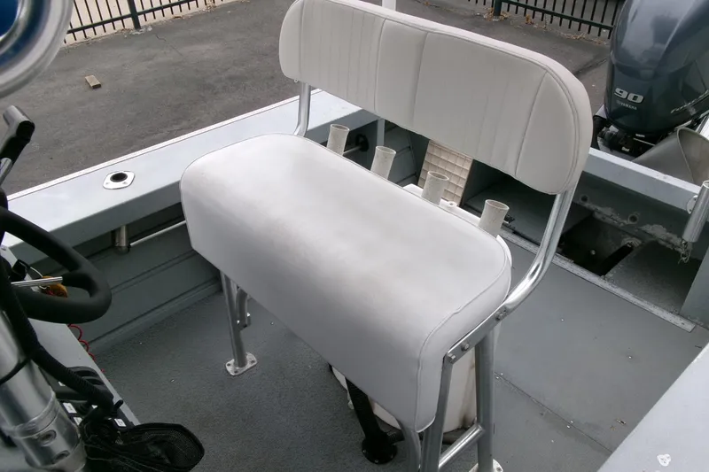 Slide: The Image of 2017 Klamath Bayrunner 19 Baja boat interior with white cushioned seating and rod holders. - 12