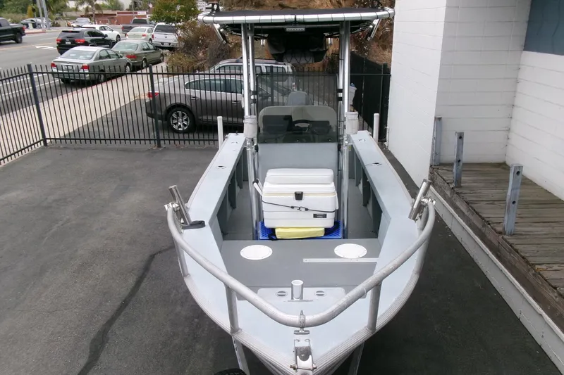 Slide: The Image of 2017 Klamath Bayrunner 19 Baja boat parked, featuring a central console and storage cooler. - 17