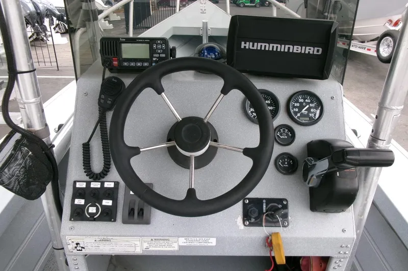 Slide: The Image of 2017 Klamath Bayrunner 19 Baja boat dashboard with steering wheel, gauges, and Humminbird electronics. - 9