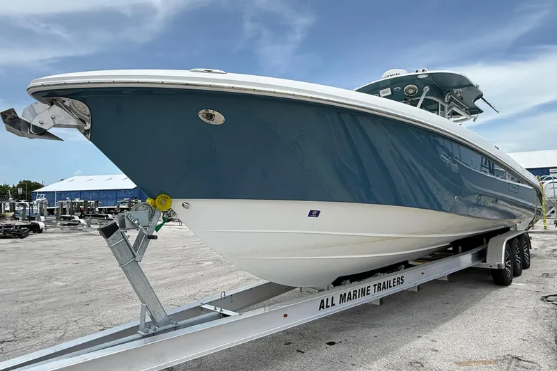 The Image of 2009 Everglades 350 Center Console boat on trailer, parked outdoors under a clear sky. - 0