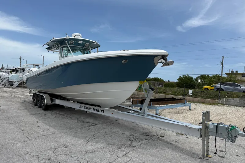 Slide: The Image of 2009 Everglades 350 Center Console boat on trailer, parked outdoors under a clear sky. - 2