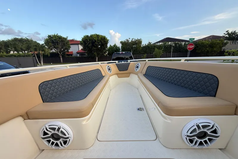 Slide: The Image of 2014 Custom Latitude Powerboats 28 CC interior with cushioned seating and speakers. - 40