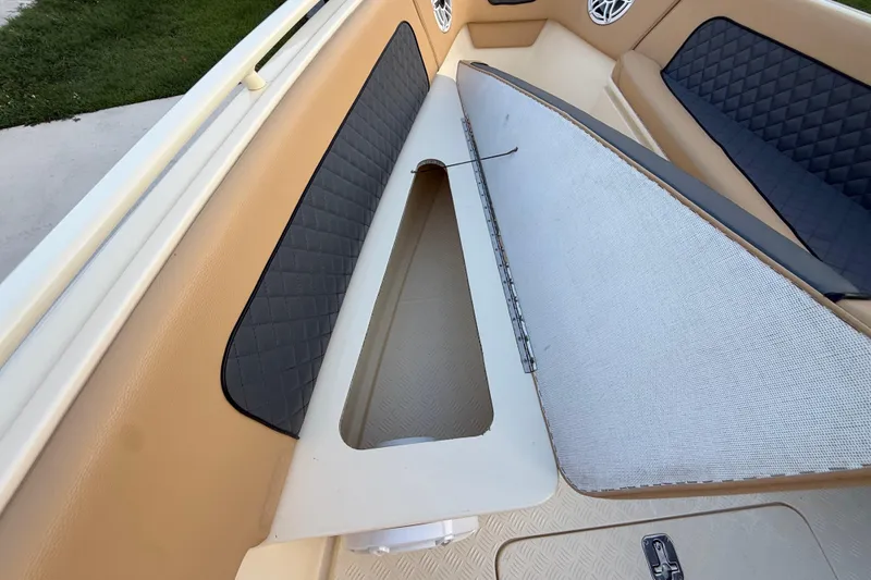 Slide: The Image of Open storage compartment on 2014 Custom Latitude Powerboats 28 CC with cushioned seating. - 34