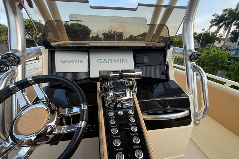Slide: The Image of 2014 Custom Latitude Powerboats 28 CC dashboard with Garmin navigation systems and sleek controls. - 16