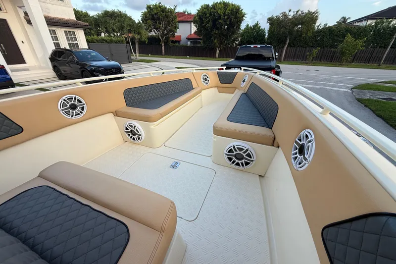 Slide: The Image of 2014 Custom Latitude Powerboats 28 CC interior with cushioned seating and built-in speakers. - 31