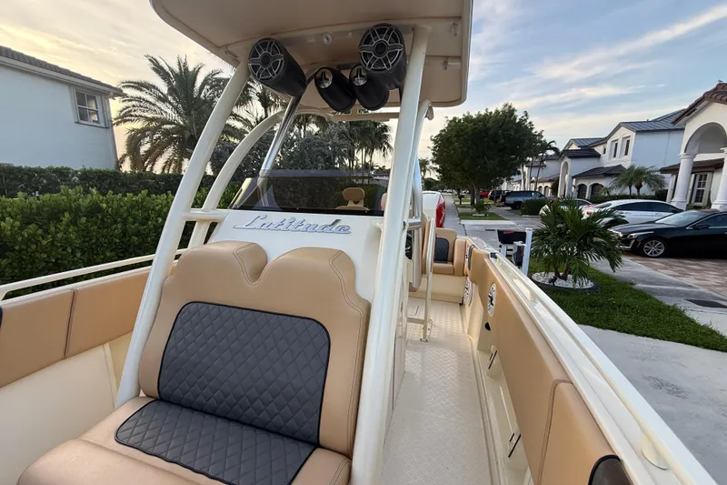 Slide: The Image of 2014 Custom Latitude Powerboats 28 CC with tan seating, parked in a residential area. - 30