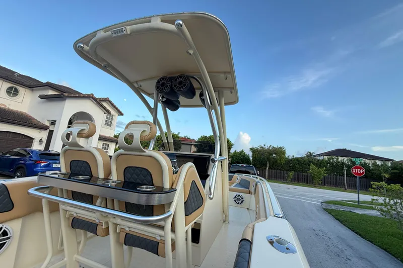 Slide: The Image of 2014 Custom Latitude Powerboats 28 CC with seating, parked in a residential area. - 14