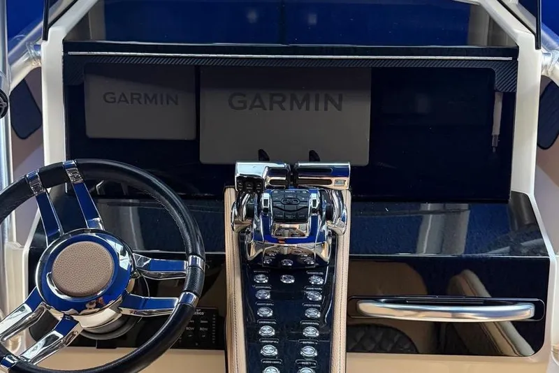 Slide: The Image of 2014 Latitude 28 CC boat dashboard with Garmin navigation and chrome steering wheel. - 11