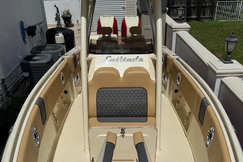 Slide: The Image of 2014 Latitude 28 CC boat interior with tan and gray seating, outdoor setting. - 14