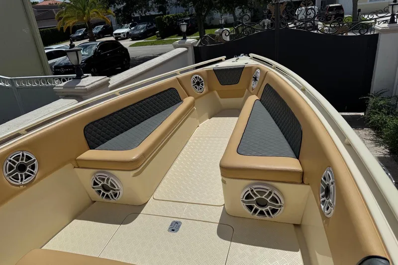 Slide: The Image of 2014 Latitude 28 CC boat interior with tan seating and built-in speakers. - 15