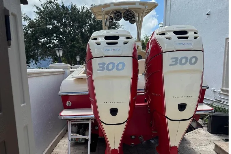 Slide: The Image of 2014 Latitude 28 CC boat with twin 300 horsepower outboard engines, parked outdoors. - 3
