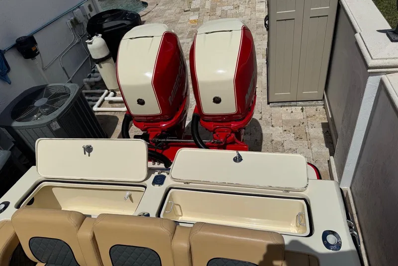 Slide: The Image of 2014 Latitude 28 CC boat with dual red outboard motors and open storage compartments. - 4