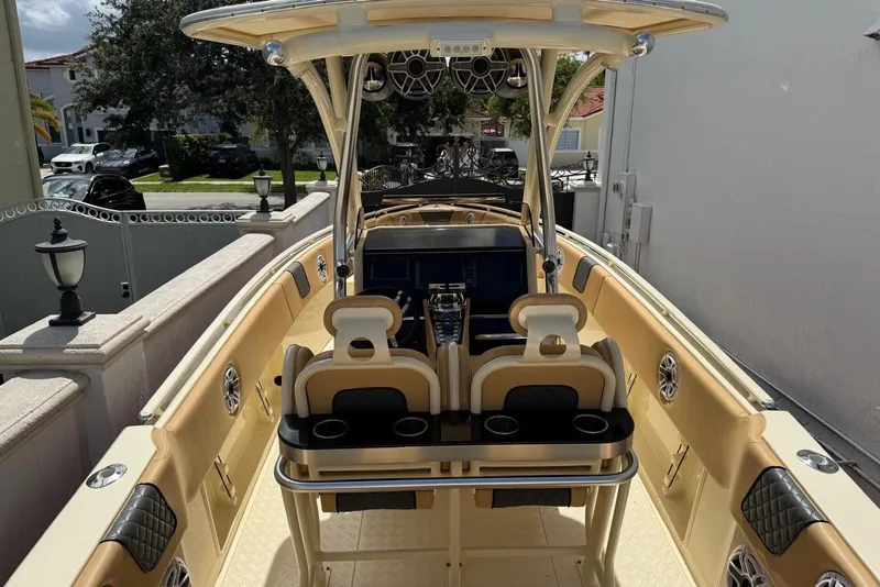 Slide: The Image of 2014 Latitude 28 CC boat interior with beige seating and modern console. - 5