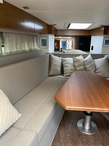 Slide: The Image of Interior of a 2018 Cruisers Yachts 39 Express Coupe with cozy seating area and wooden table. - 17