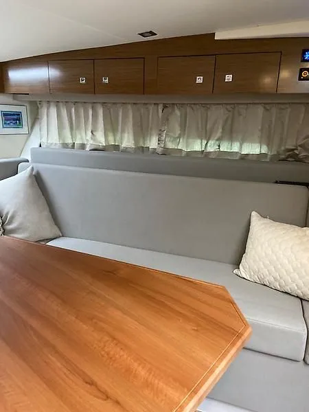 Slide: The Image of Interior of a 2018 Cruisers Yachts 39 Express Coupe with gray sofa and wooden table. - 18