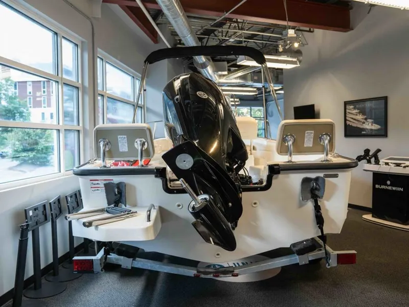 Slide: The Image of A 2026 Boston Whaler 170 Montauk is displayed in a showroom. The outboard motor is visible. - 3