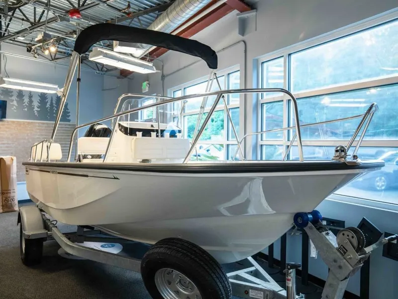 The Image of A 2026 Boston Whaler 170 Montauk sits on a trailer in a showroom. - 1
