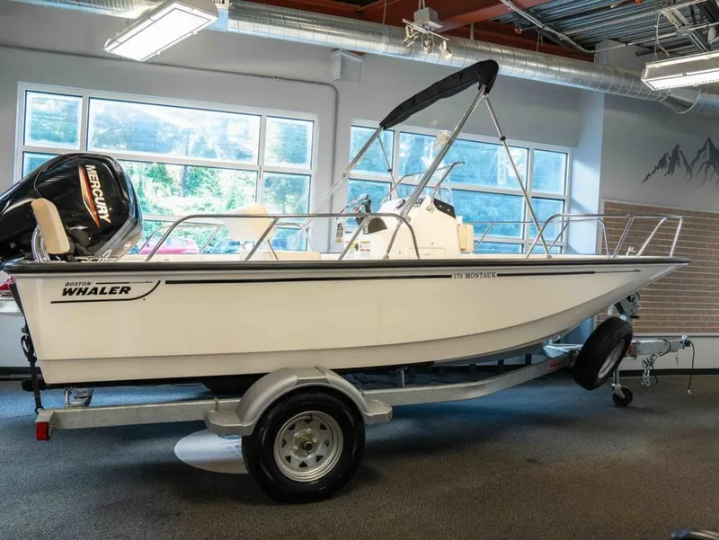 Slide: The Image of A 2026 Boston Whaler 170 Montauk on a trailer in a showroom setting. - 2