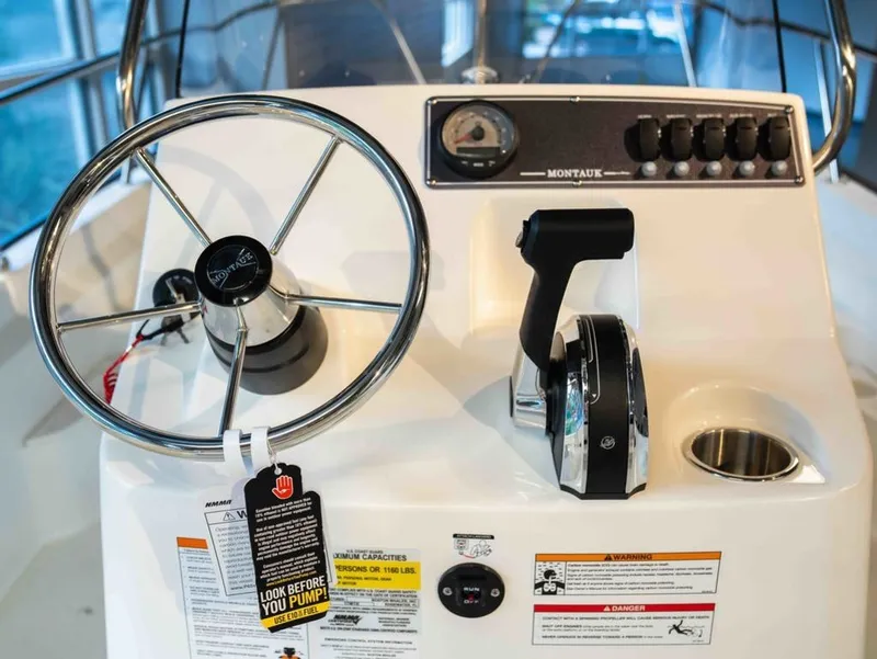 Slide: The Image of The image shows the helm of a Boston Whaler 170 Montauk with a steering wheel and throttle. - 8