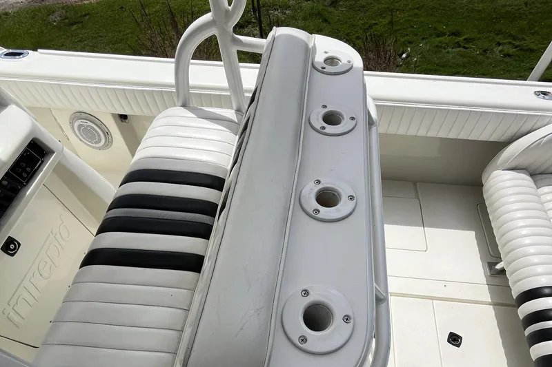 Slide: The Image of 1994 Intrepid 30 Open Cuddy boat interior with white and black seating and rod holders. - 11