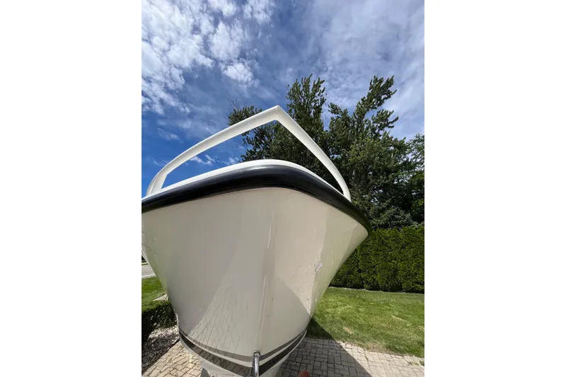 Slide: The Image of 1994 Intrepid 30 Open Cuddy boat, bow view, against a blue sky and trees. - 16