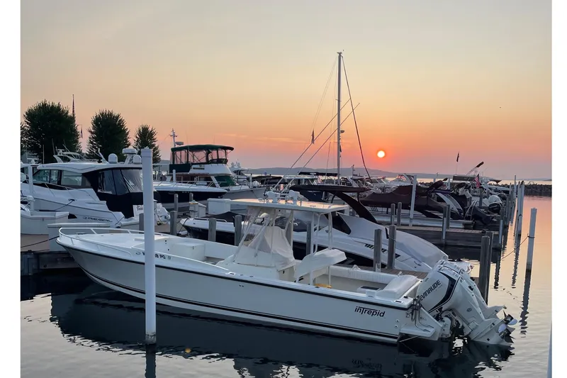 Slide: The Image of 1994 Intrepid 30 Open Cuddy boat docked at sunset in a serene marina. - 2