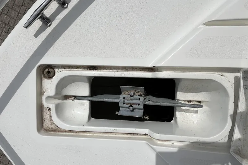 Slide: The Image of Anchor compartment of a 1994 Intrepid 30 Open Cuddy boat, showing metal cleat and anchor. - 22