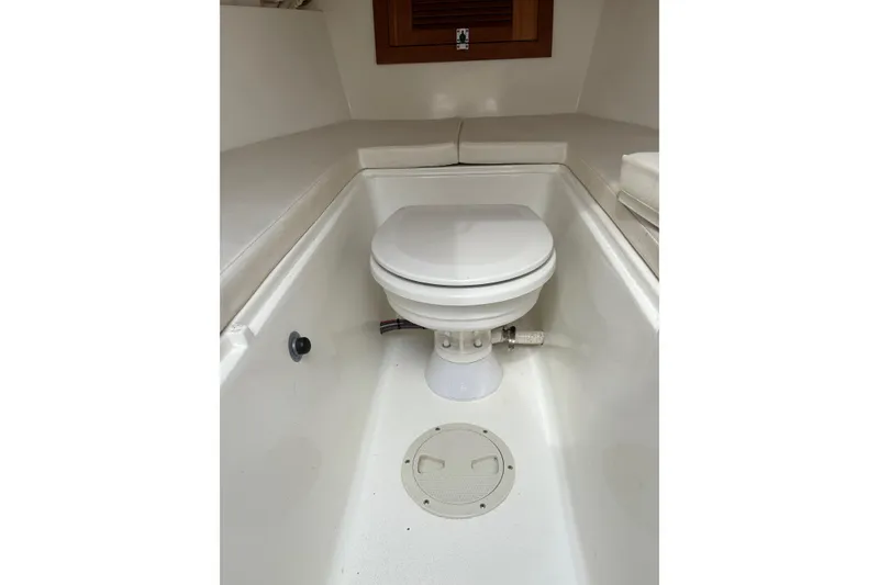 Slide: The Image of 1994 Intrepid 30 Open Cuddy boat interior with a compact marine toilet. - 24