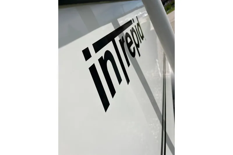 Slide: The Image of Close-up of 1994 Intrepid 30 Open Cuddy boat logo on white hull. - 6