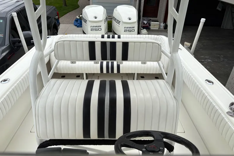 Slide: The Image of 1994 Intrepid 30 Open Cuddy boat interior with striped seating and dual Evinrude 250 engines. - 8