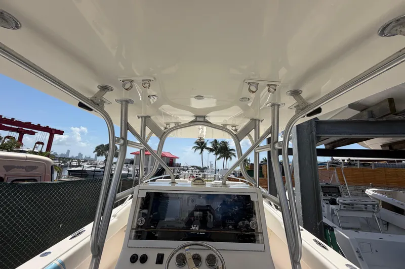 Slide: The Image of 2009 SeaVee 340B Cuddy boat interior with helm, marina view, and palm trees. - 11