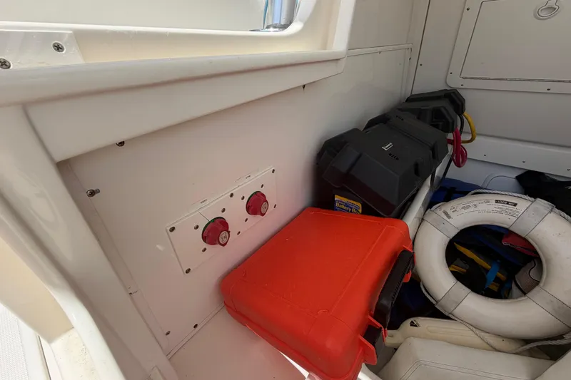 Slide: The Image of Storage area in a 2009 SeaVee 340B Cuddy boat with safety equipment and battery switches. - 16