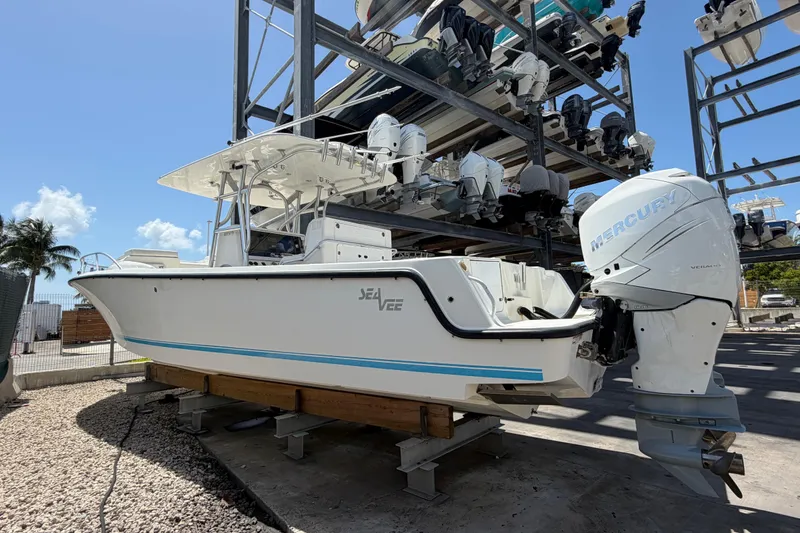 Slide: The Image of 2009 SeaVee 340B Cuddy boat with Mercury engine, stored on a rack under a clear sky. - 2