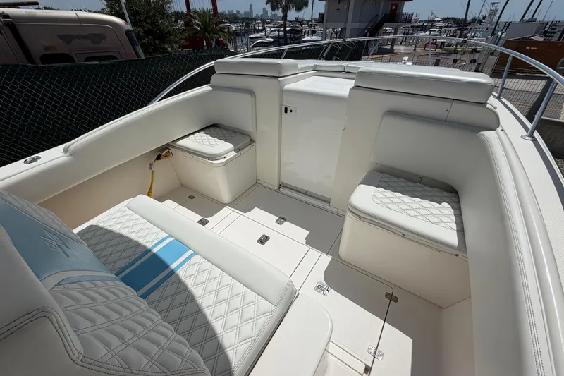 Slide: The Image of 2009 SeaVee 340B Cuddy boat interior with white cushioned seating and storage compartments. - 28