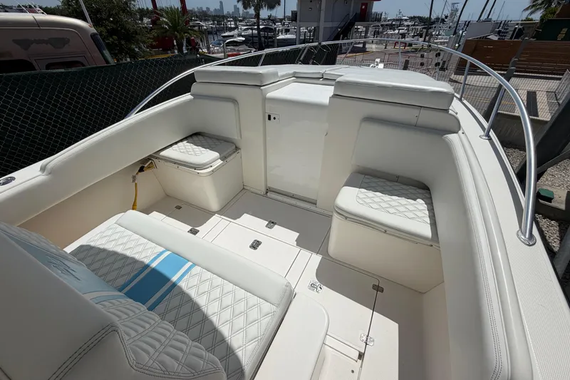 Slide: The Image of 2009 SeaVee 340B Cuddy boat interior with white cushioned seating and storage compartments. - 29