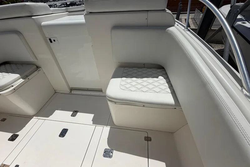Slide: The Image of 2009 SeaVee 340B Cuddy interior with white cushioned seating and storage compartments. - 30